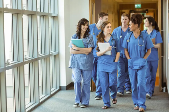 staff in scrubs wearing dosimeters used in research labs